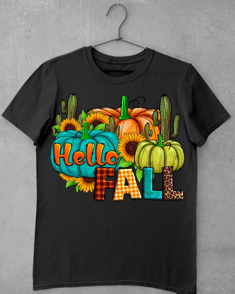 May include: Black t-shirt with a graphic design featuring pumpkins, sunflowers, and cacti. The text "Hello Fall" is written in colorful letters.