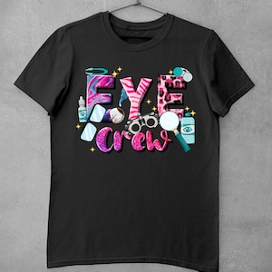 May include: Black t-shirt with a pink, blue, and white graphic that says "EYE crew". The graphic includes images of eye-related objects like glasses, eye drops, and a magnifying glass.