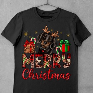 May include: Black and brown dachshund wearing reindeer antlers with a red and green plaid "Merry Christmas" text and Christmas-themed decorations.