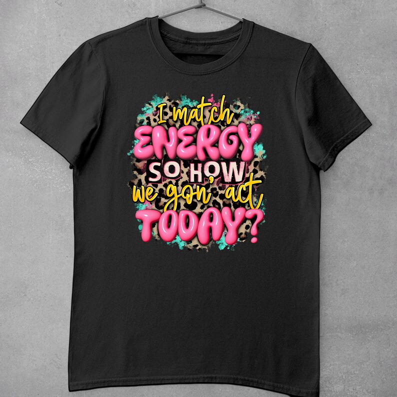 May include: Black t-shirt with a pink graphic that says "I match energy so how we gon' act today?" The graphic is surrounded by a leopard print pattern and blue paint splatters.