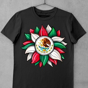 以下が含まれることがあります： 緑、白、赤の花柄の黒いTシャツ。花の中心には、サボテンにとまっているワシが描かれたメキシコの紋章があります。