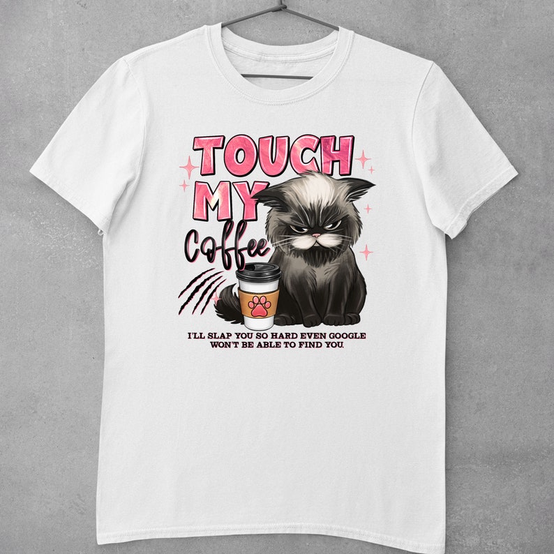 May include: White t-shirt with a black cat graphic holding a coffee cup. The text "TOUCH MY COFFEE" is in pink letters above the cat. Below the cat, the text reads "I'LL SLAP YOU SO HARD EVEN GOOGLE WON'T BE ABLE TO FIND YOU."