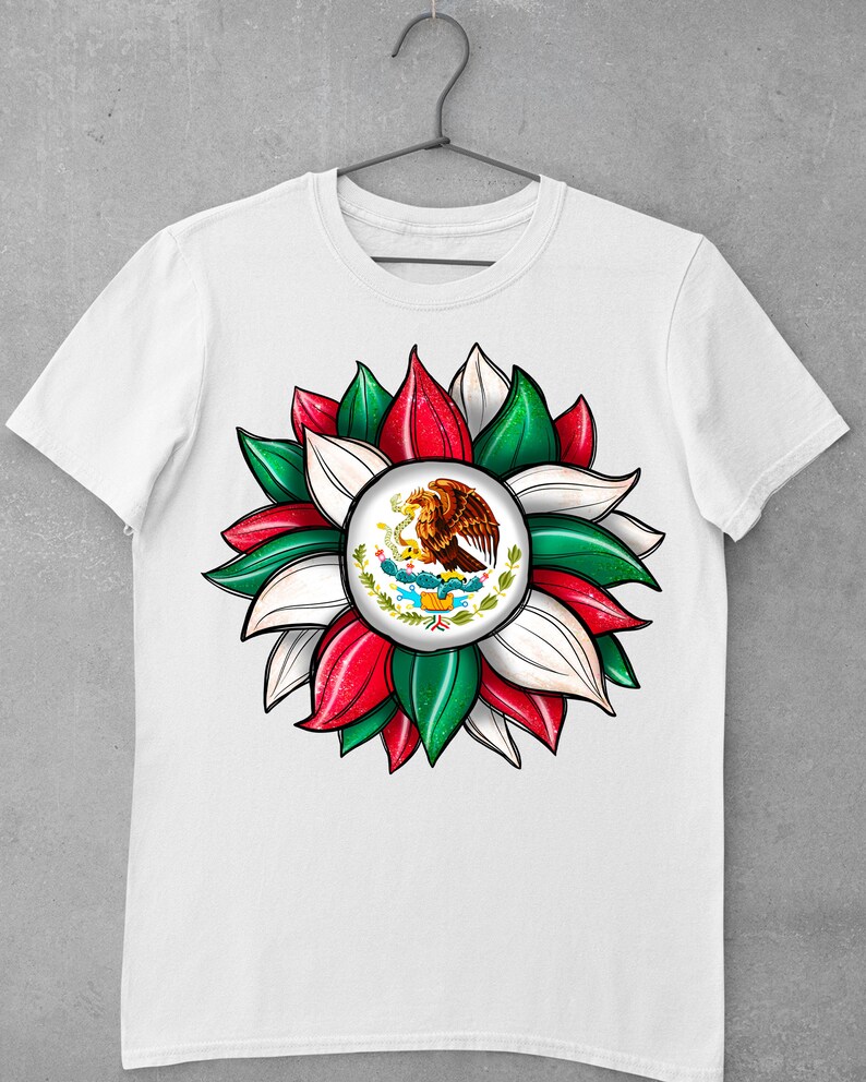 以下が含まれることがあります： 緑、白、赤の花のデザインが施された白いTシャツ。花の中心には、サボテンにとまっているワシが描かれたメキシコの紋章があります。