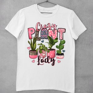 Pu&ograve; includere: Maglietta bianca con un design grafico rosa e nero che dice "Crazy Plant Lady" con una variet&agrave; di piante in vaso in vasi rosa.