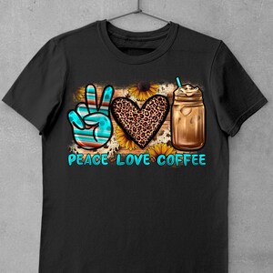 May include: Black t-shirt with a peace sign, heart, and iced coffee graphic. The peace sign is blue and white, the heart is leopard print, and the coffee is in a mason jar with a straw. The text "Peace Love Coffee" is below the graphic.