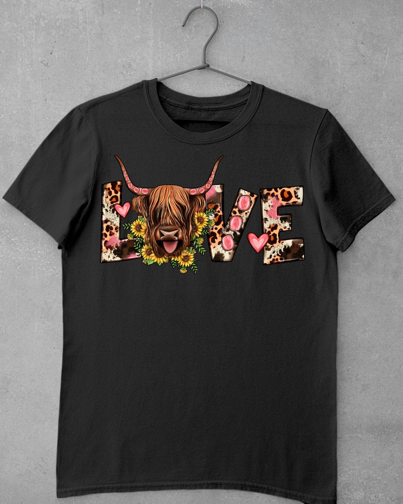 May include: Black t-shirt featuring a graphic of a Highland cow with a pink heart and the word "LOVE" in a leopard print pattern.