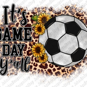 Puede incluir: Texto "It's Game Day y'all" sobre un fondo blanco con un bal&oacute;n de f&uacute;tbol y girasoles sobre un fondo de estampado de leopardo marr&oacute;n y negro.