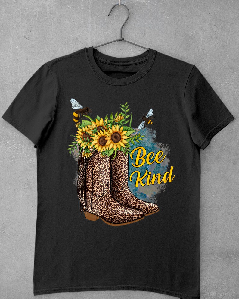 May include: Black t-shirt with a graphic of a pair of leopard print cowboy boots with sunflowers and bees. The text "Bee Kind" is written in white letters.