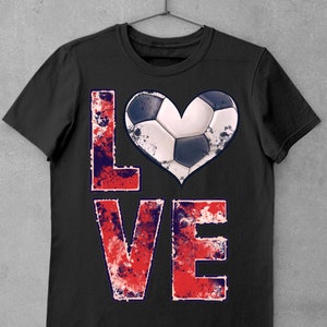 Puede incluir: Camiseta negra con un gr&aacute;fico desgastado en rojo, blanco y azul de la palabra "LOVE" con un bal&oacute;n de f&uacute;tbol en forma de coraz&oacute;n.