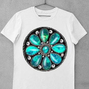 Op de afbeelding: Wit T-shirt met een cirkelvormig ontwerp in turquoise en zilver, dat lijkt op een bloem met meerdere turquoise edelstenen.