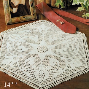 May include: A white crocheted doily with a delicate floral design. The doily is laid out on a wooden surface. The text "14*" is visible in the bottom left corner of the image.