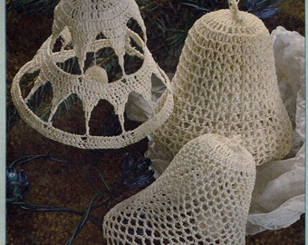 May include: Three crocheted white bell ornaments. The bells are made with a delicate openwork pattern and are hanging from a string.
