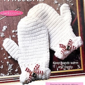May include: A pair of white crocheted mittens with red and white gingham ribbon accents and a small bell charm. The mittens are shown on a book with the text "Keep hands warm and toasty." and "Quick Crochet".