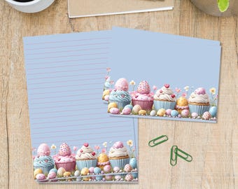 May include: Light blue stationery with pink lined paper and a decorative border featuring cupcakes and Easter eggs. The image includes a cup of coffee, a pen, and green paper clips on a wooden surface.