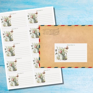 Könnte beinhalten: Adressetiketten und ein Umschlag mit floralem Design. Die Etiketten und der Umschlag zeigen ein Aquarelldesign einer Gießkanne mit Blumen und Schmetterlingen. Der Text "Please Deliver To:" ist auf den Etiketten aufgedruckt.