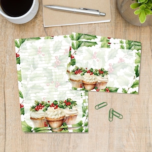 Op de afbeelding: Briefpapier set met gelijnd papier en notecards met een feestelijk ontwerp. Het ontwerp bevat illustraties van cupcakes met room en hulstbessen, omringd door groene hulstbladeren.