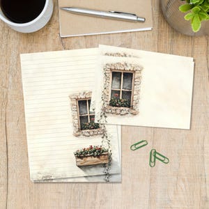 May include: Stationery set featuring a cream-coloured lined sheet and a matching blank card, both decorated with a watercolour illustration of a stone wall, a wooden window frame, and a window box filled with red flowers and green vines.