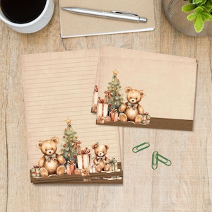 Op de afbeelding: Briefpapier set met een kerstthema. Het ontwerp bevat illustraties van teddyberen, kerstbomen en ingepakte cadeaus. Het briefpapier heeft een vel met lijnen en verschillende blanco notitiekaarten. Het kleurenpalet is zacht, met warme tinten.