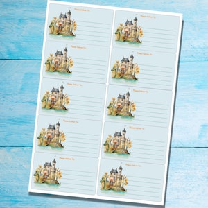 May include: Eight blue and white address labels with a watercolor illustration of a castle and a dragon. Each label has the text "Please Deliver To:" printed on it.