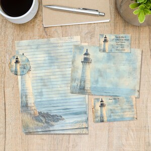 Peut inclure: Ensemble de papeterie avec un motif de phare. Comprend du papier ligné, des cartes postales et un autocollant avec les mots "Happy Mail". Le phare est représenté dans un style aquarelle avec des tons bleus et beiges. Un stylo et une tasse de café sont également visibles.