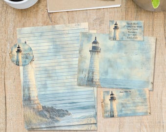 May include: Stationery set featuring a lighthouse design. Includes lined paper, postcards, and a round sticker with the words "Happy Mail." The lighthouse is depicted in a watercolor style with blue and beige tones. A pen and coffee cup are also visible.