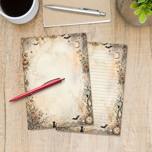 Op de afbeelding: Twee vellen briefpapier met een vintage Halloween-thema, voorzien van illustraties van pompoenen, rozen, vleermuizen, schedels, zakhorloges en spinnenwebben. Eén vel is blanco, het andere heeft horizontale lijnen om op te schrijven.