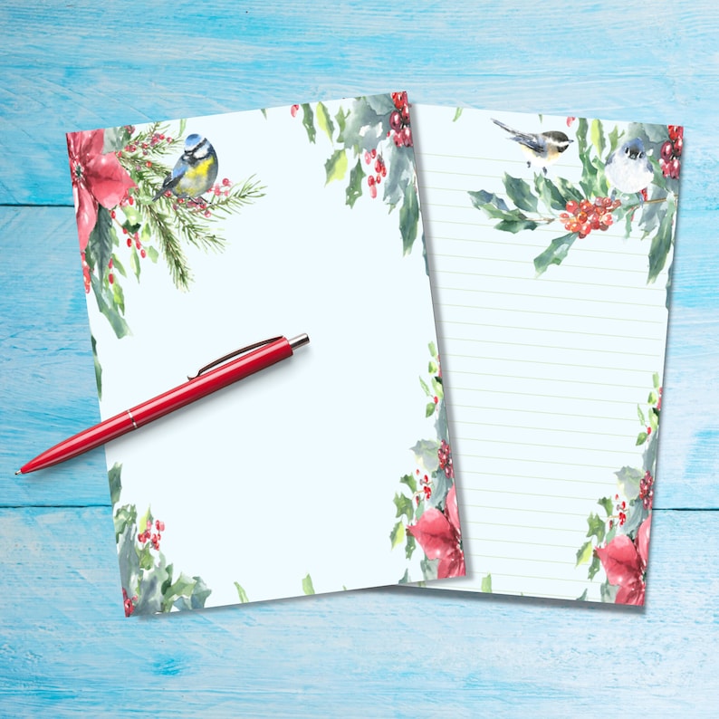 May include: Two blank stationery sheets with a holly and berry border. The sheets have a blue bird and red berries on the top and bottom. One sheet has lined paper and the other is blank.