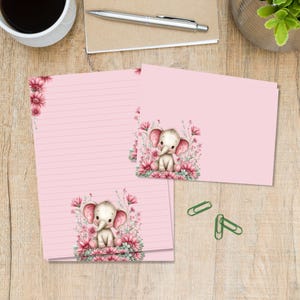 Op de afbeelding: Roze briefpapier set met een gelijnde briefvel en blanco kaarten. Elk stuk heeft een bloemenhoekontwerp en een aquarel illustratie van een baby-olifant omringd door bloemen. Voor het schrijven van brieven en notities.