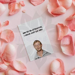 May include: A greeting card with the text "YOU'RE SO ATTRACTIVE, I COULD JUST EAT YOU." features a photo of a man wearing glasses. The card is surrounded by pink rose petals on a pink background.