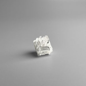 May include: A clear plastic mechanical keyboard switch, also known as a keycap switch, is a component used in computer keyboards. It is a small, rectangular piece of plastic that is designed to be pressed down by a keycap.