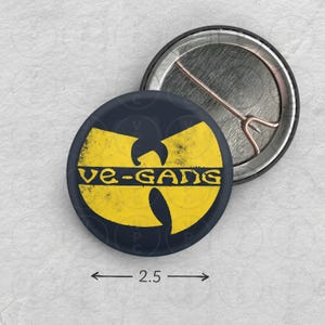 May include: A 2.5 inch button featuring a yellow Wu-Tang Clan logo with the text "Wu-Gang" on a dark blue background.