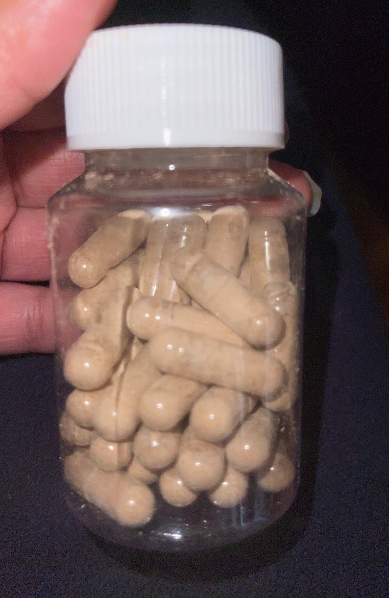 May include: A clear plastic bottle filled with a large quantity of brown capsules. The bottle has a white lid.