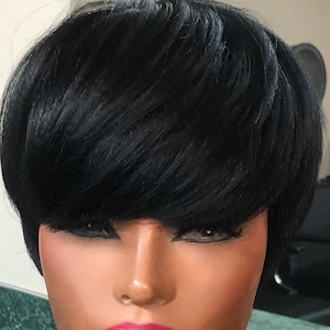 May include: A short black wig with a blunt cut and side bangs. The wig is styled with a sleek, straight look.