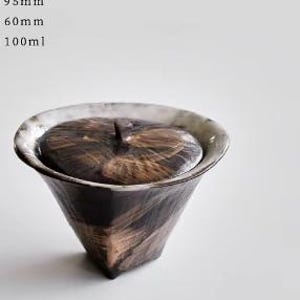 Pu&ograve; includere: Un piccolo contenitore per t&egrave; in ceramica nero e bianco con coperchio. Il contenitore ha un design testurizzato e geometrico e misura 9,5 cm di altezza, 6 cm di larghezza e ha una capacit&agrave; di 100 ml.
