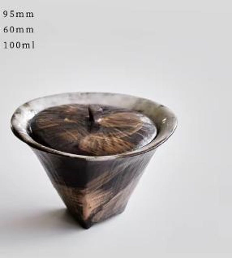 Pu&ograve; includere: Un piccolo contenitore per t&egrave; in ceramica nero e bianco con coperchio. Il contenitore ha un design testurizzato e geometrico e misura 9,5 cm di altezza, 6 cm di larghezza e ha una capacit&agrave; di 100 ml.