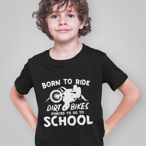 May include: Black t-shirt with a white graphic of a person riding a dirt bike with the text "Born to Ride Dirt Bikes Forced to Go to School".