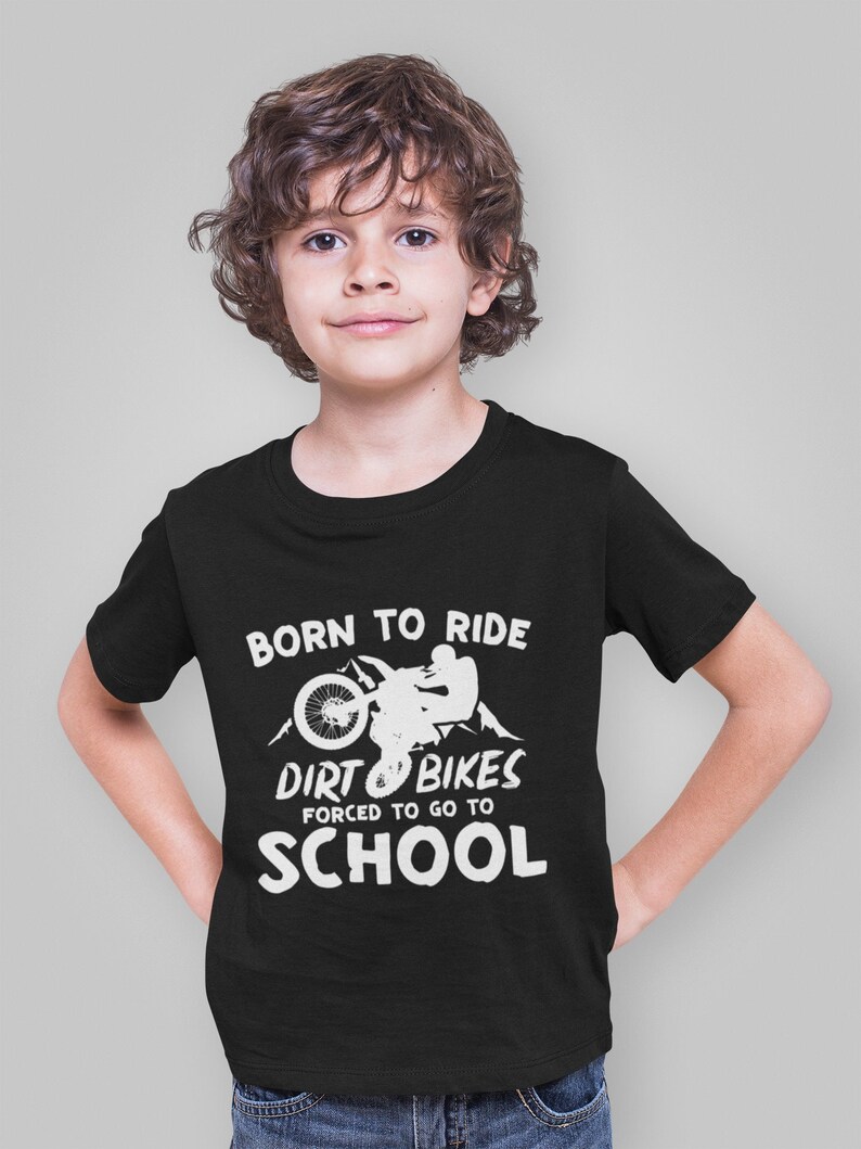 May include: Black t-shirt with a white graphic of a person riding a dirt bike with the text "Born to Ride Dirt Bikes Forced to Go to School".