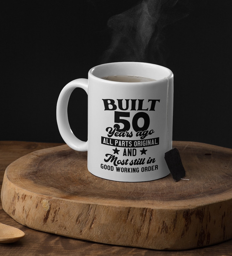 May include: White ceramic mug with a black design that reads "BUILT 50 Years ago ALL PARTS ORIGINAL ★ AND ★ Most still in GOOD WORKING ORDER".
