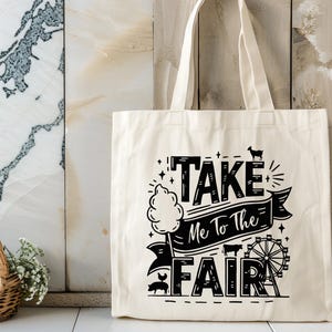 May include: A white canvas tote bag with black text that reads "Take Me To The Fair" with a graphic of a Ferris wheel, a pig, and a goat.