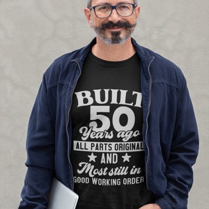 May include: A black t-shirt with white text that reads "BUILT 50 Years ago ALL PARTS ORIGINAL AND Most still in GOOD WORKING ORDER".