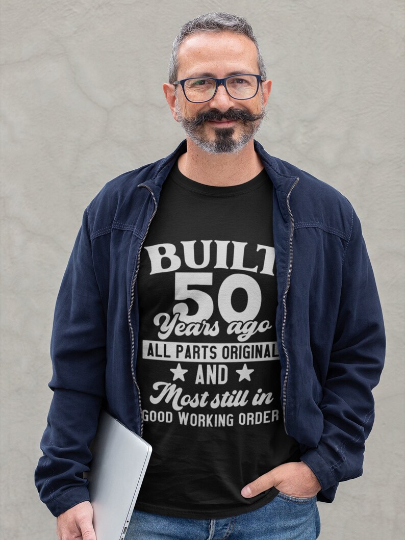 May include: A black t-shirt with white text that reads "BUILT 50 Years ago ALL PARTS ORIGINAL AND Most still in GOOD WORKING ORDER".
