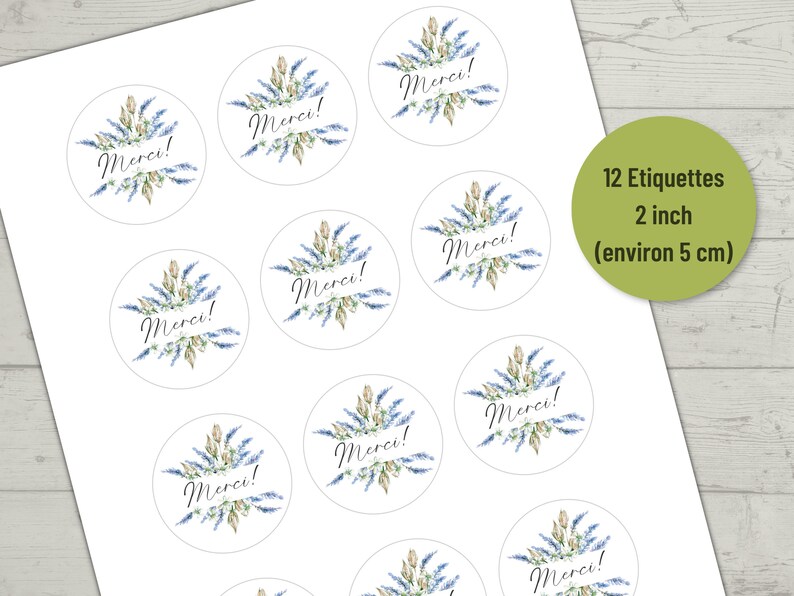 May include: Twelve 2-inch round stickers with a watercolor design of blue and green flowers and the word "Merci!" in black script.