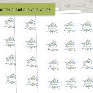 May include: A sheet of white paper with 24 round stickers featuring a watercolor design of blue and green flowers with the word "Merci!" in black script.