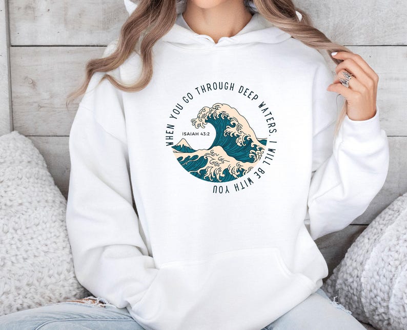 K&ouml;nnte beinhalten: Wei&szlig;er Hoodie mit einem blauen und wei&szlig;en Wellendesign und dem Text "When you go through deep waters. I will be with you. Isaiah 43:2"