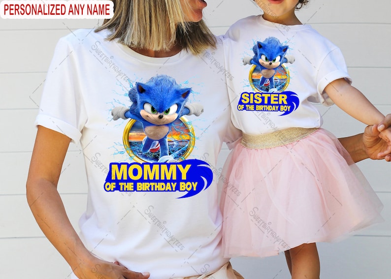 Peut inclure: Un t-shirt blanc avec un graphisme bleu de Sonic le h&eacute;risson. Le t-shirt dit "Maman du gar&ccedil;on d'anniversaire". Un deuxi&egrave;me t-shirt blanc avec un graphisme bleu de Sonic le h&eacute;risson dit "S&oelig;ur du gar&ccedil;on d'anniversaire".
