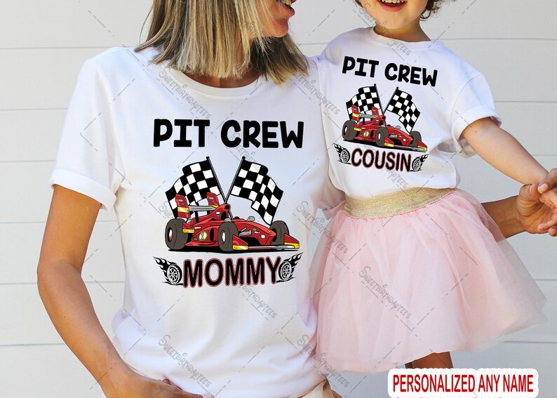 Pu&ograve; includere: Due magliette bianche con una grafica di un'auto da corsa rossa e bandiere a scacchi. Il testo sulle magliette recita "Pit Crew Mommy" e "Pit Crew Cousin".