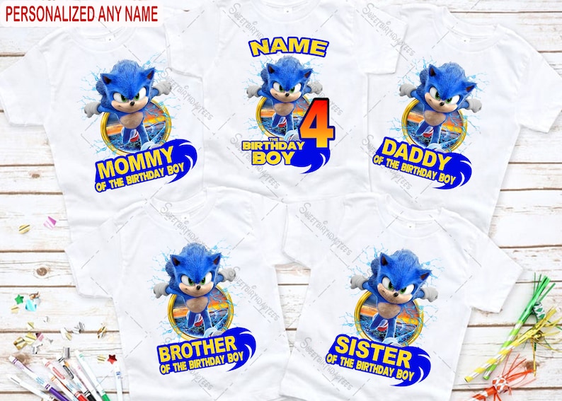 Peut inclure: Cinq t-shirts blancs avec un motif bleu de Sonic le h&eacute;risson. Les t-shirts portent le texte "Maman du gar&ccedil;on d'anniversaire", "Papa du gar&ccedil;on d'anniversaire", "Fr&egrave;re du gar&ccedil;on d'anniversaire", "S&oelig;ur du gar&ccedil;on d'anniversaire" et "Le 4&egrave;me anniversaire du gar&ccedil;on".