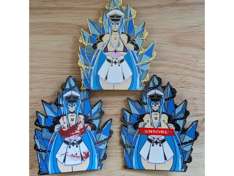 May include: Three enamel pins featuring an anime character with blue hair and a white sailor uniform. The character is surrounded by blue and silver crystals and chains. The pins are in different color variations: gold, black, and red.