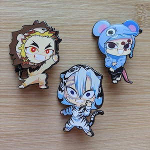 Könnte beinhalten: Drei Emaille-Pins mit Anime-Charakteren in Tierkostümen. Der erste Pin ist ein Löwe mit einer gelben Mähne und einem rot-weißen Gesicht. Der zweite Pin ist ein Tiger mit einem weiß-schwarz gestreiften Muster und einem blauen Gesicht. Der dritte Pin ist eine Maus mit einem blau-weißen Kostüm und einem rot-weißen Gesicht.