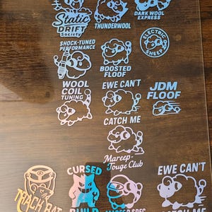 May include: A collection of stickers featuring cartoon sheep and various text designs. The stickers include phrases like "Static Drift Society," "Thunderwool," "Boosted Floof," and "Electric Sheep." The color palette includes shades of blue, white, and gold.
